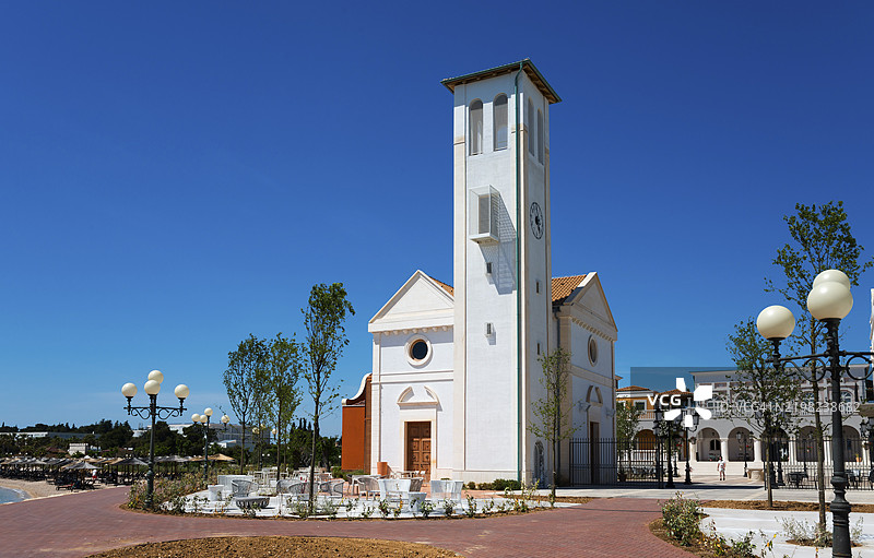 白色教堂塔楼建筑位于海滨长廊旁，蓝天映衬下，阿马德里亚公园，希贝尼克，希贝尼克-克宁，达尔马提亚，克罗地亚，欧洲图片素材