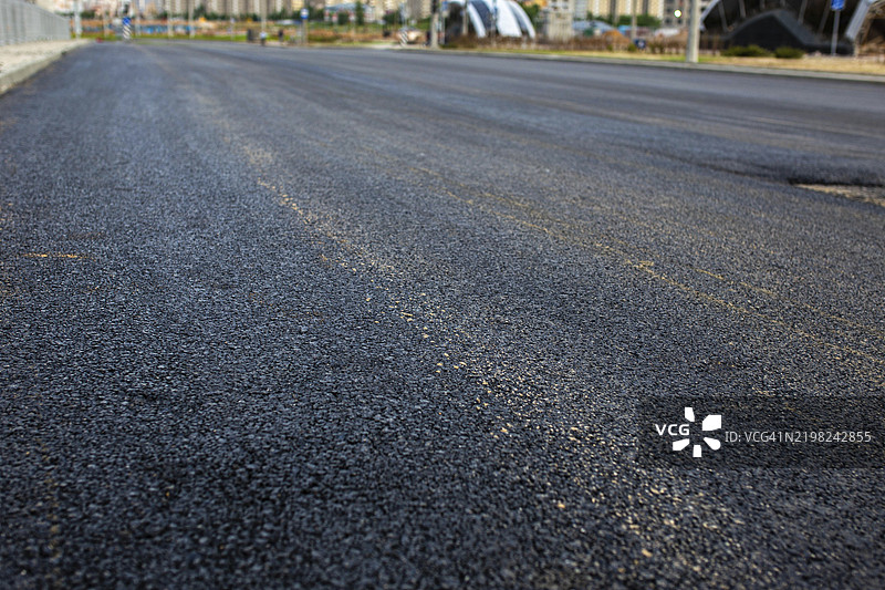 新铺设的道路延伸至城市环境中的远方图片素材