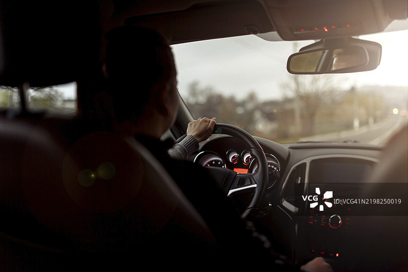 在昏暗的灯光下开车的人，营造出一种平静而专注的氛围图片素材