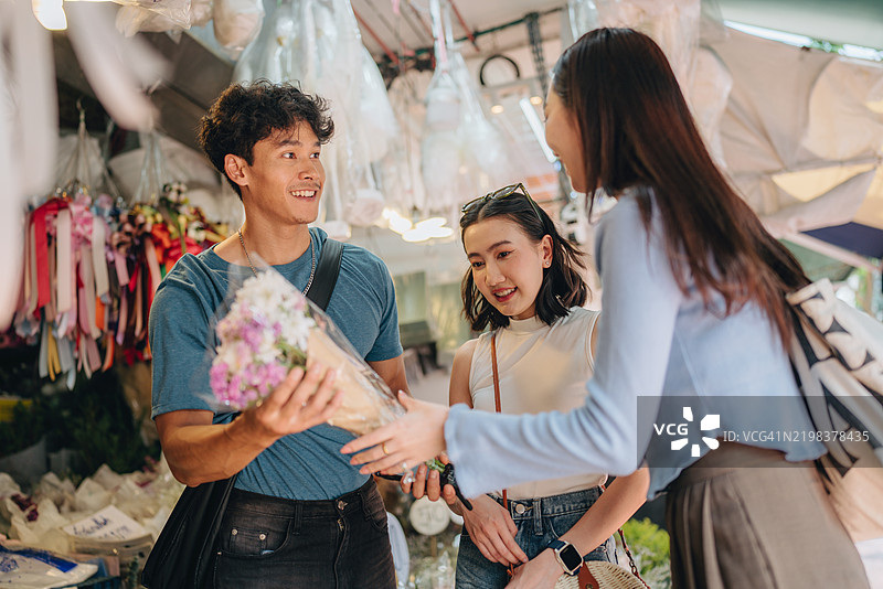 当地市场 / 和朋友一起购物。女人在商店里提着购物篮购买花盆。图片素材