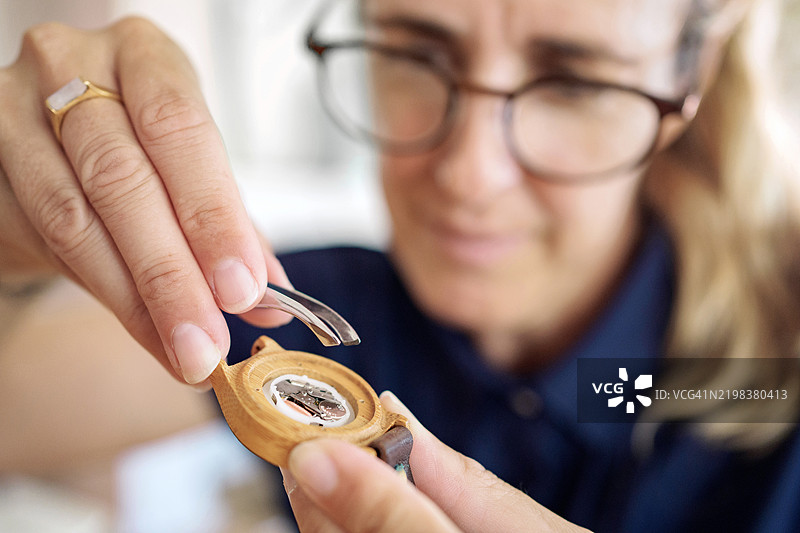 女性在制表工作坊修理手表图片素材