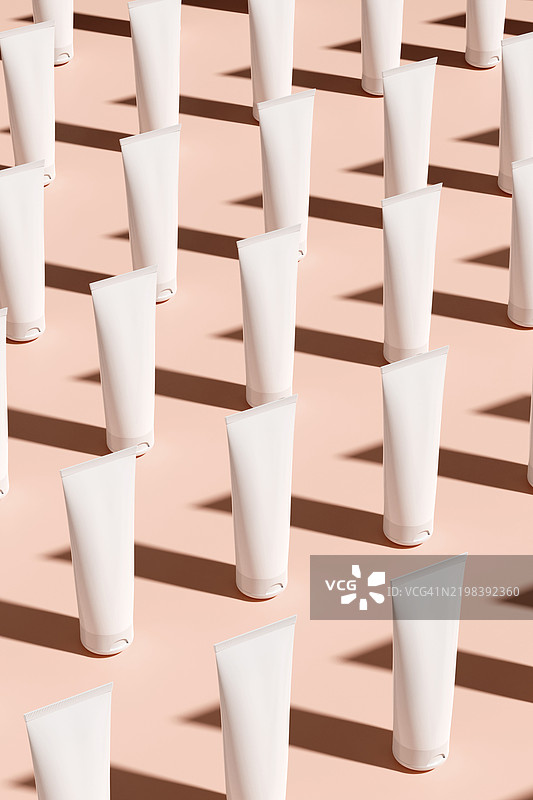 面霜、粉底、晒黑乳液、护发素管和瓶子在米色竖直背景上的3D图案。化妆和护肤的美容产品。2025年潘通色彩年度色摩卡慕斯。图片素材