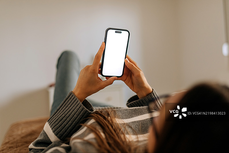 放松在家中，特写镜头下的无法辨认的女性使用手机图片素材