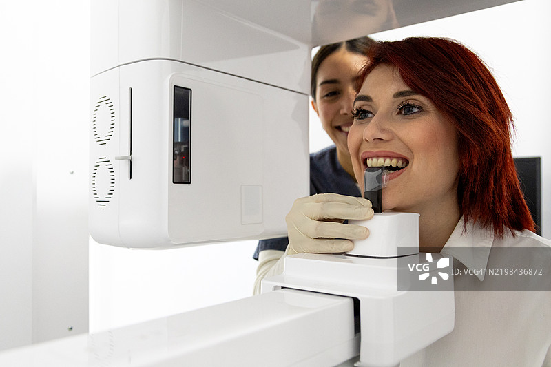 牙医为微笑的患者进行锥形束计算机断层扫描图片素材