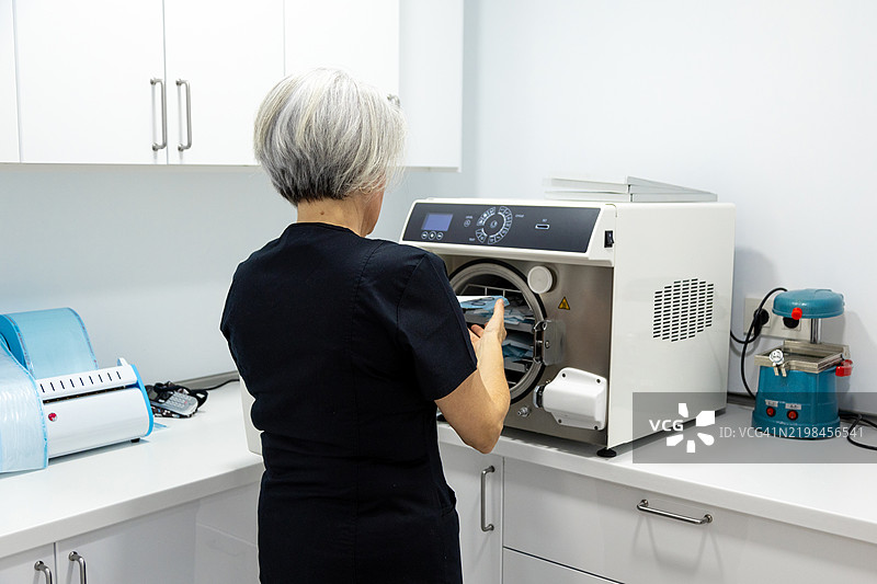 护士在诊所的高压灭菌器中消毒医疗器械图片素材