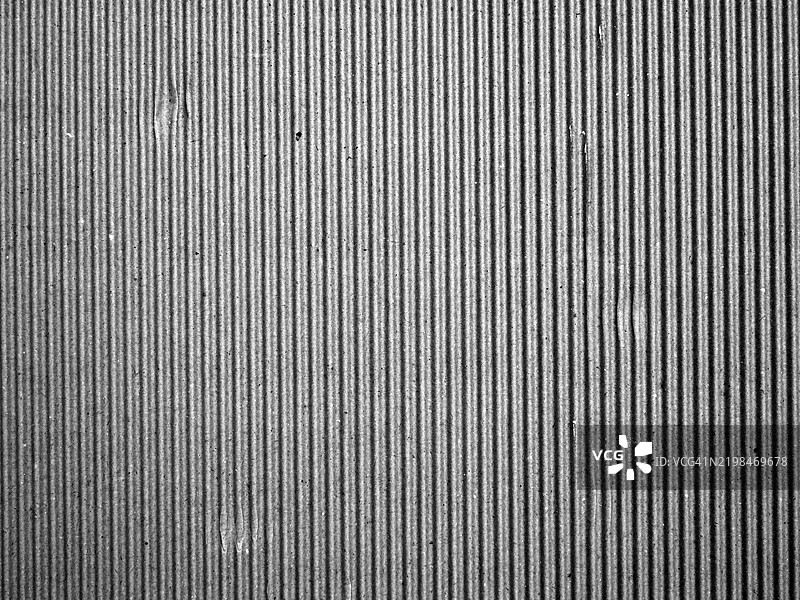 条纹状、灰色且具有铜绿的纸板背景。粗糙纹理。图片素材