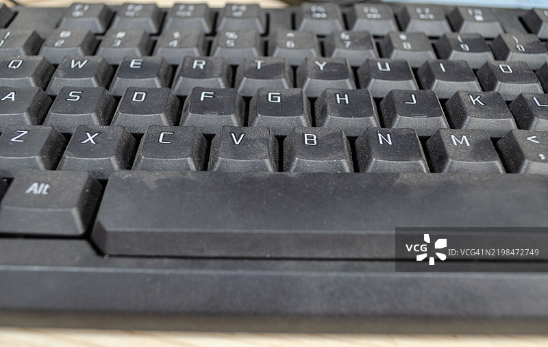 办公室电脑键盘从未清洁或消毒。办公室电脑键盘上布满了灰尘。图片素材