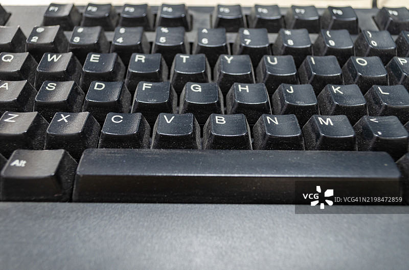 办公室的电脑键盘从未清洁或消毒，键盘上布满了灰尘。图片素材