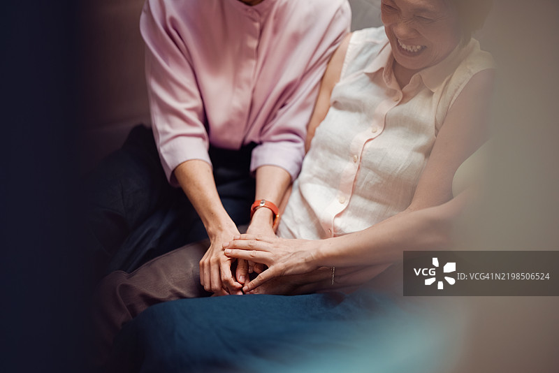 两位女性在轻松愉快的环境中欢笑并牵着手图片素材