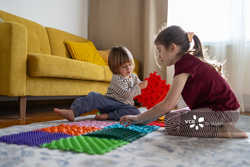 兄弟姐妹们在一起玩耍。预防扁平足的方法在家中。图片素材