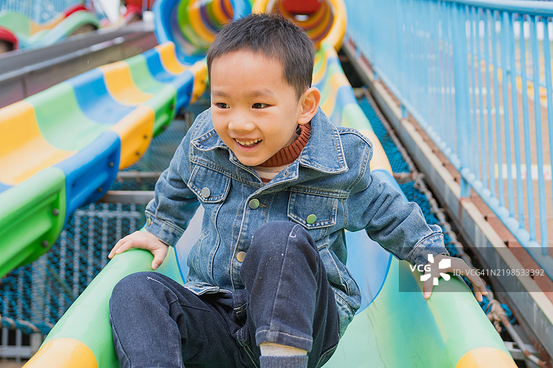 小男孩在游乐园玩耍；无动力游乐园娱乐设施图片素材