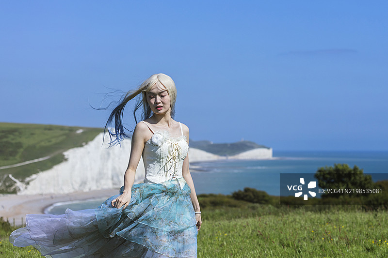 在英国布莱顿的七姐妹悬崖旁，一位美丽的日本女孩的肖像图片素材