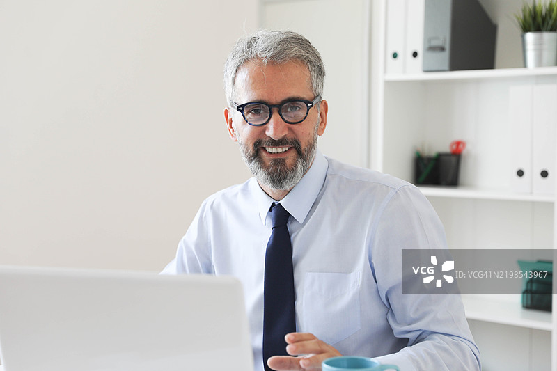 专注的高级商务人士在办公室工作图片素材