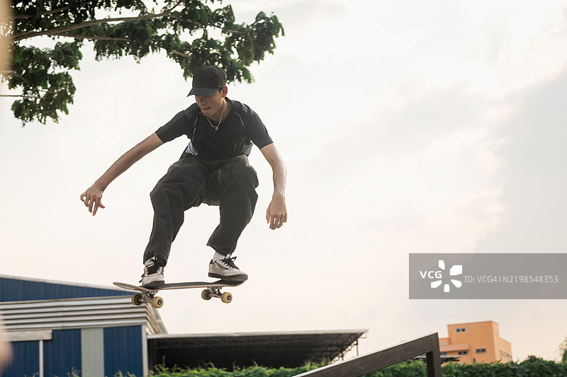 年轻滑板手在极限滑板特技中空中跳跃图片素材