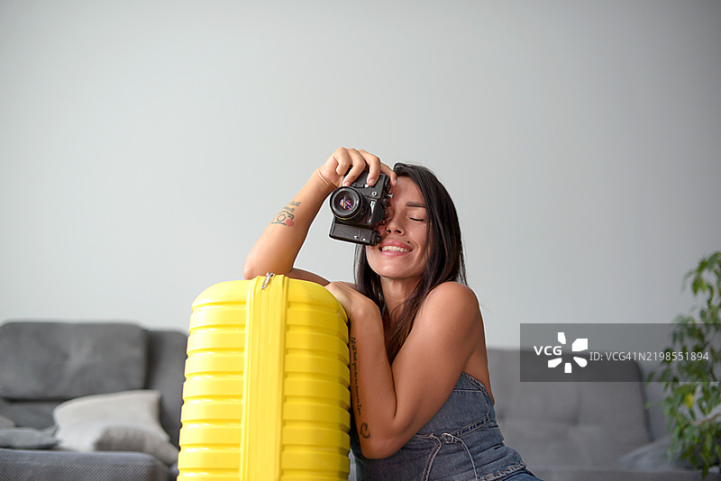 中年女性正在打包行李并手持相机图片素材