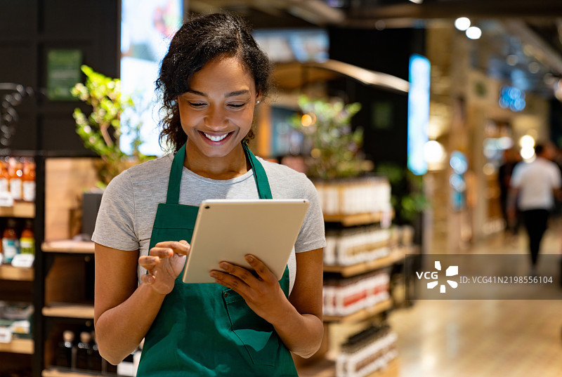 超市的零售店员正在使用数字平板电脑图片素材