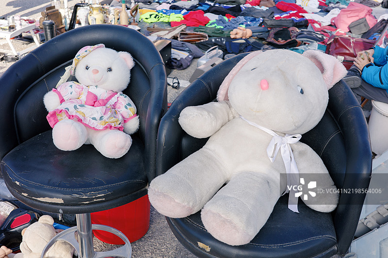 两只白色泰迪熊坐在两把黑色高椅上图片素材