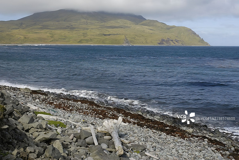 阿拉斯加阿达克岛岩石海滩上的山与水图片素材