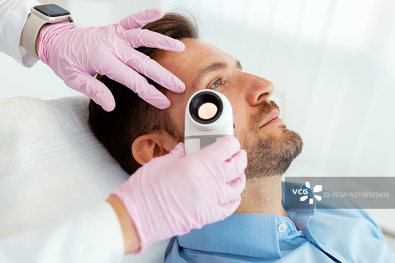 皮肤科医生对患者进行皮肤镜检查图片素材