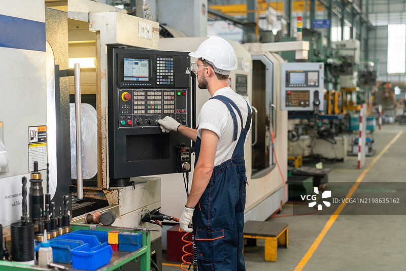 男性工厂工人操作数控机床图片素材