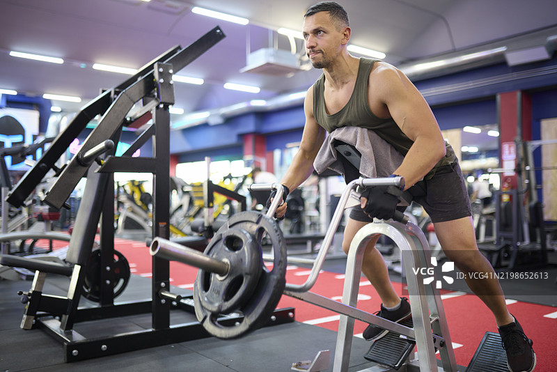 男子在健身房进行负重背部伸展图片素材