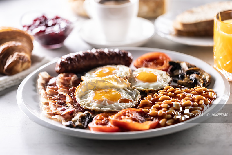 自制全英式早餐，包括鸡蛋、香肠、火腿、西红柿、蘑菇和豆子图片素材