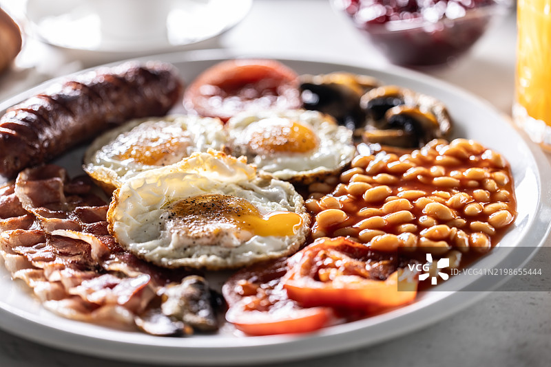 自制全英式早餐，包括鸡蛋、香肠、火腿、西红柿、蘑菇和豆子图片素材