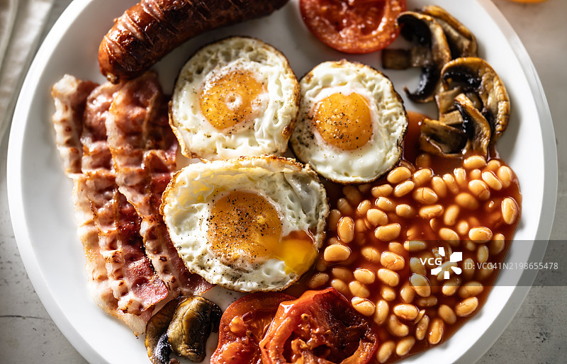自制全英式早餐，包括鸡蛋、香肠、火腿、西红柿、蘑菇和豆子图片素材