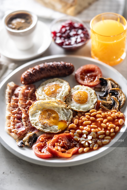 自制全英式早餐，包括鸡蛋、香肠、火腿、西红柿、蘑菇和豆子图片素材
