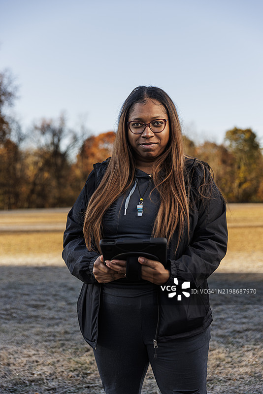 女子橄榄球队教练的肖像，站在球场上图片素材