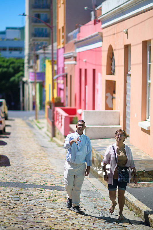 年轻男性导游与一位年长女性游客在开普博卡普马来区散步图片素材