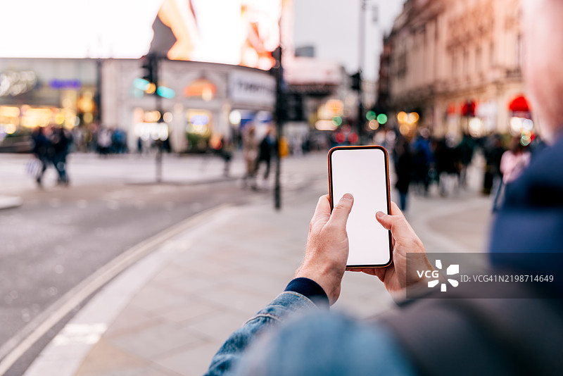 在英国伦敦街头，男子正在用智能手机打字图片素材
