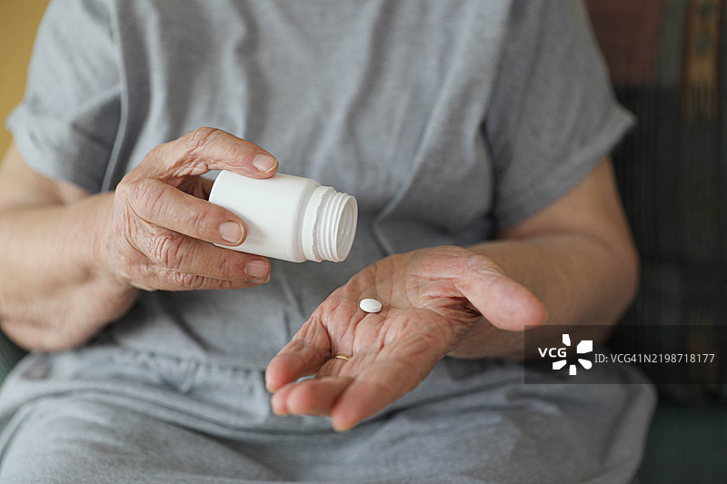 一位老年女性手持药瓶图片素材