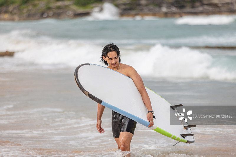 年轻的冲浪者在澳大利亚悉尼的邦迪海滩享受阳光明媚的一天，拥抱夏季的户外生活方式图片素材