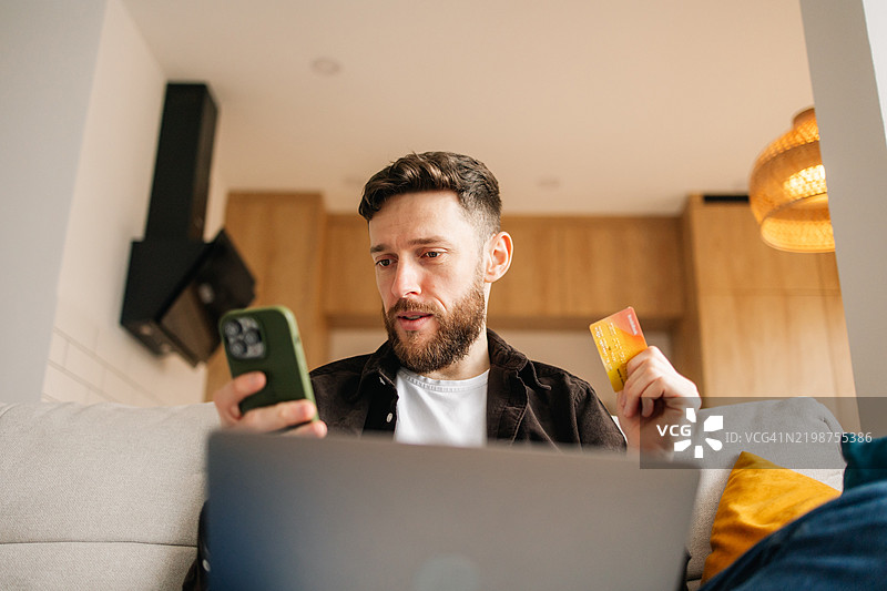 男子使用信用卡进行在线购物付款图片素材