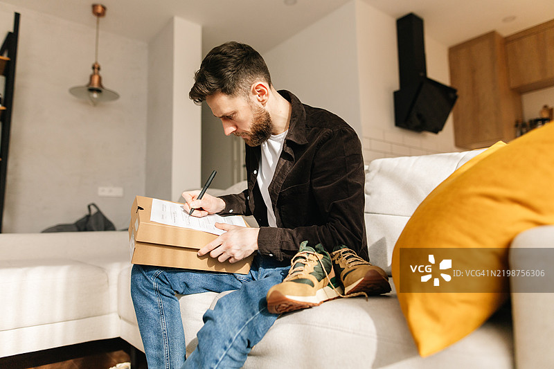 一名男子填写在线商店购买商品退货的表格图片素材