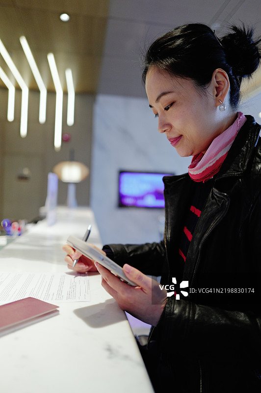 酒店接待处的女性正在签署文件图片素材