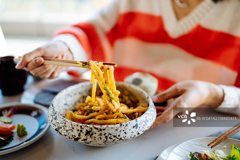 亚洲女儿和她的母亲在户外餐厅共进午餐的特写镜头。图片素材