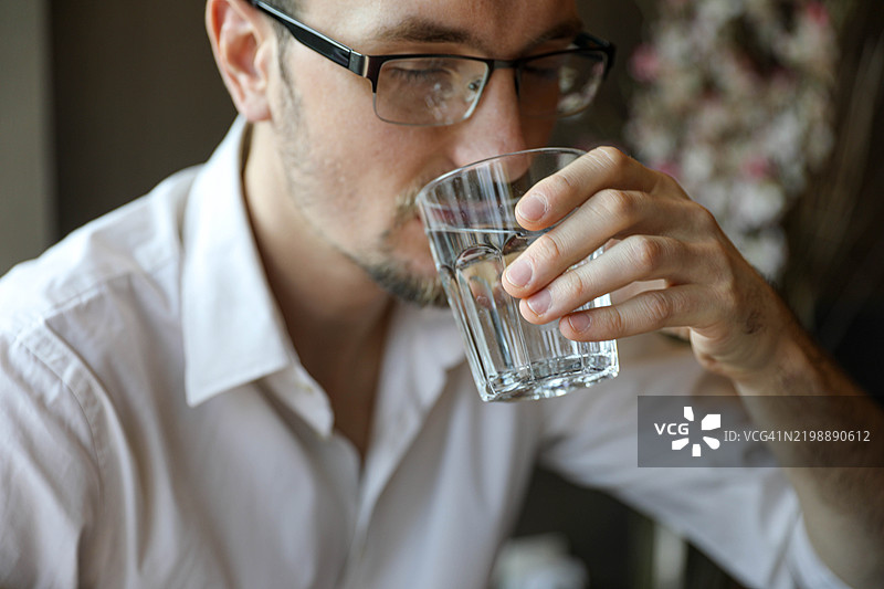 帅气的年轻男子正在喝水。图片素材