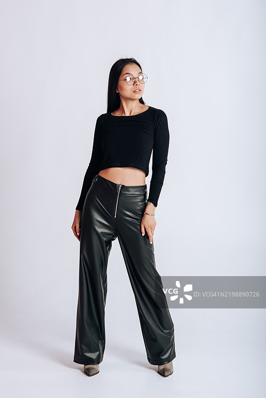 亚洲女性在白色背景的摄影棚中展示新系列服装图片素材