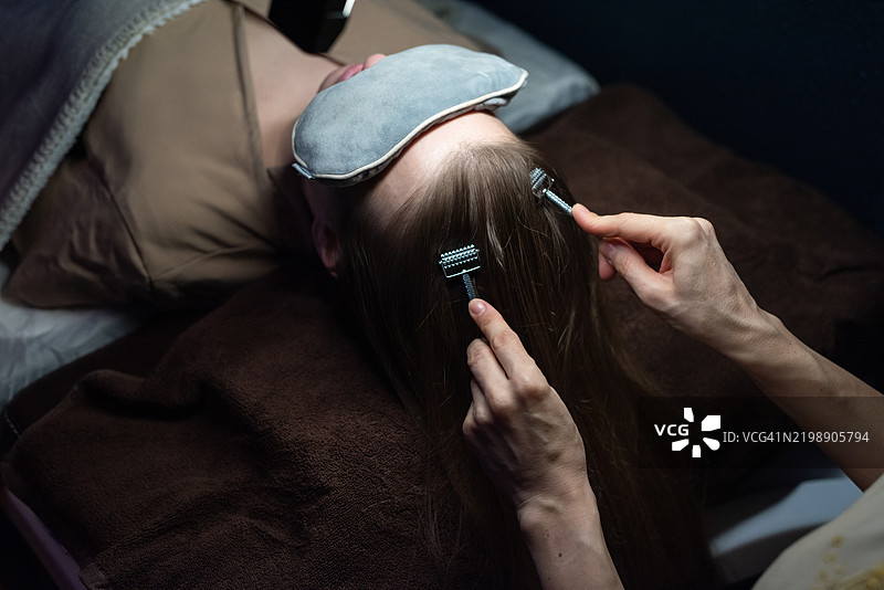 佩戴睡眠面罩的女性在享受放松按摩。图片素材