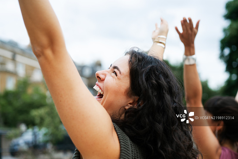 两个朋友举起手来，欢笑，玩得开心图片素材