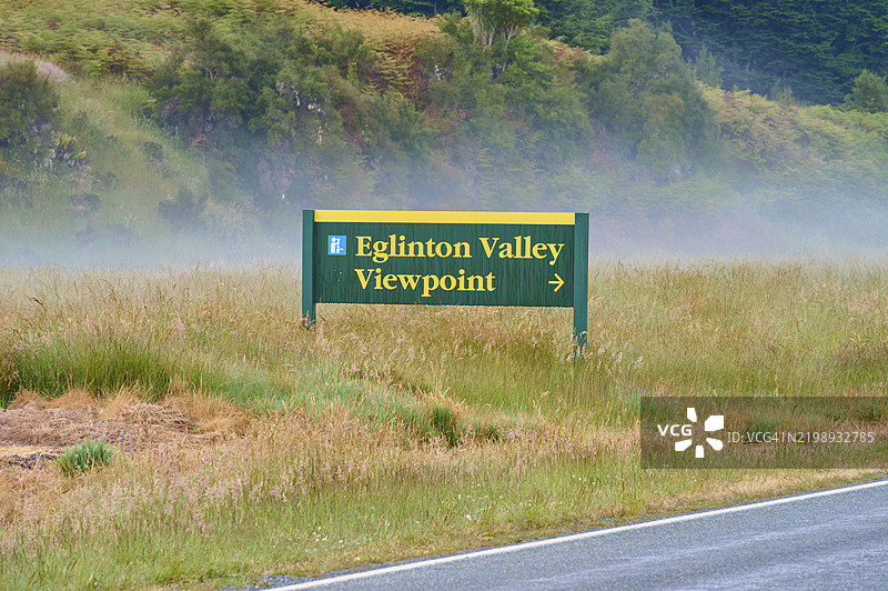 指示前往埃格林顿谷观景点的标志,周围是雾气弥漫的牧场,夏季,米尔福德峡湾,提阿瑙,菲奥德兰国家公园,新西兰南岛,大洋洲图片素材