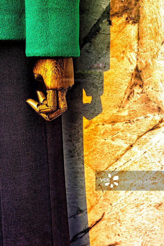 木制人偶手靠在有纹理的墙上图片素材