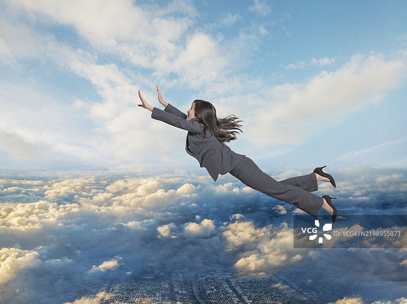 年轻女商人在天空中飞翔图片素材