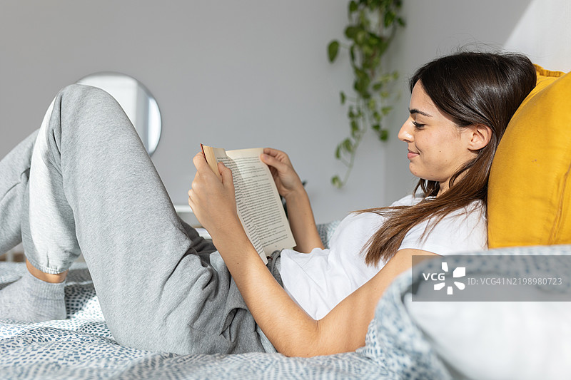年轻女性放松身心，阅读一本书图片素材