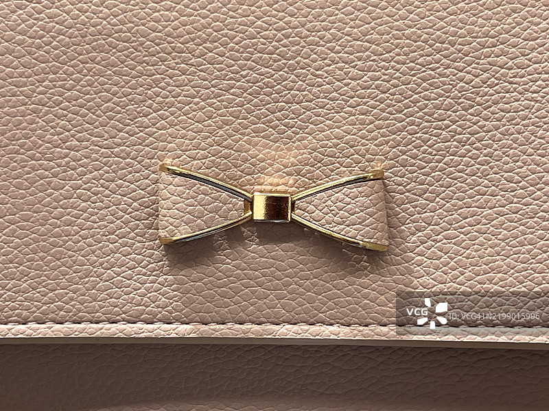 粉色手袋上的装饰性蝴蝶结细节图片素材