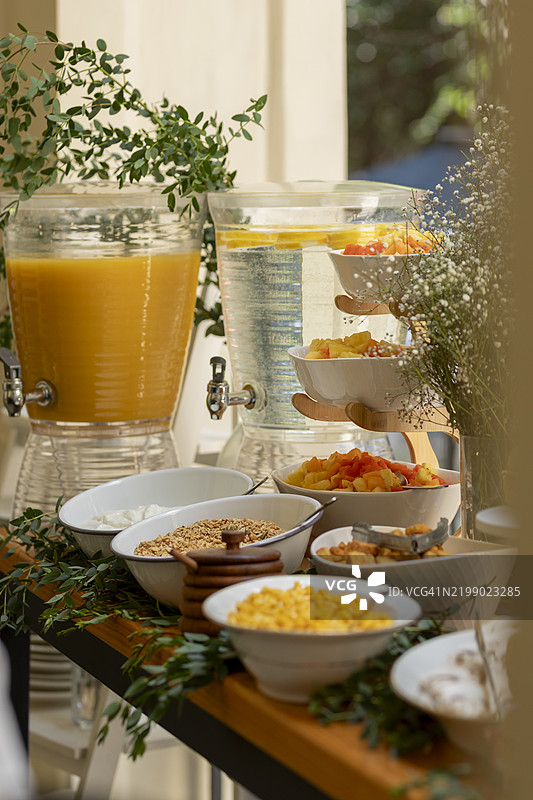 酒店自助餐桌提供新鲜水果、果汁和早餐谷物图片素材