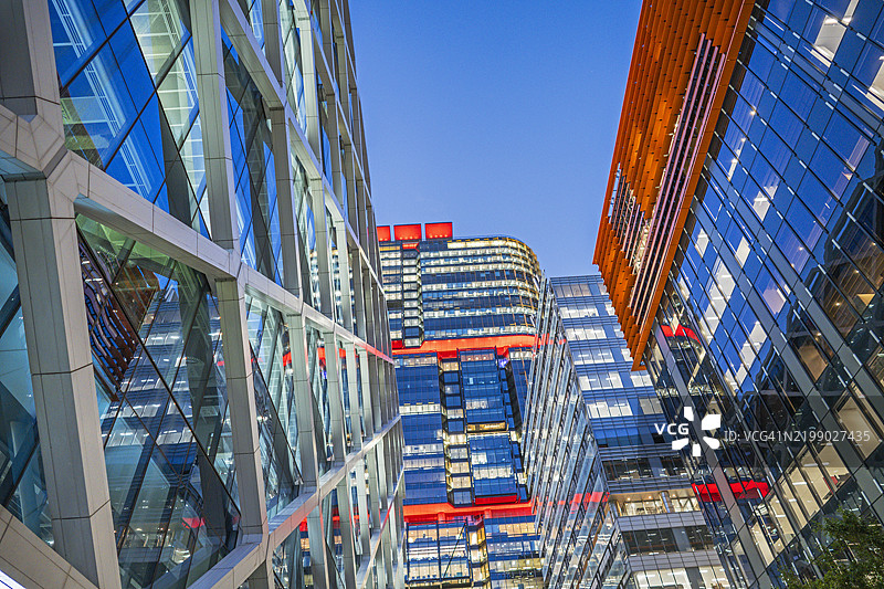 夜晚的企业办公大楼在蓝色天空下闪烁着光芒图片素材