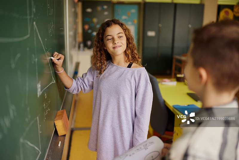 小学生在课堂上黑板上写几何图形。图片素材